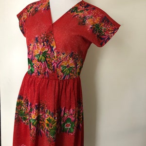 May include: A red dress with a floral print and a V-neckline. The dress has short sleeves and a fitted bodice.