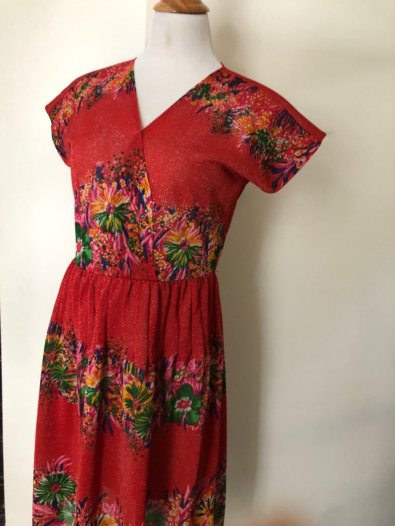 May include: A red dress with a floral print and a V-neckline. The dress has short sleeves and a fitted bodice.