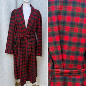 May include: A long, red, green, and black plaid robe with a matching belt. The robe has a shawl collar, long sleeves, and two front pockets. The fabric is a soft, woven material.