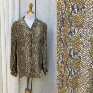 May include: A long-sleeved button-up shirt with a snakeskin print in shades of brown, gray, and white.