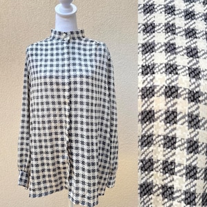 May include: A white and black gingham button-up shirt with a high collar and long sleeves.