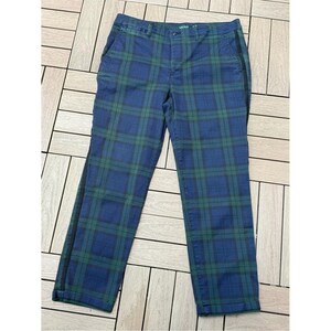 May include: Blue and green plaid pants with a black stripe down the side. The pants have a classic plaid pattern in shades of blue and green. The pants are made of a durable material and have a tailored fit.