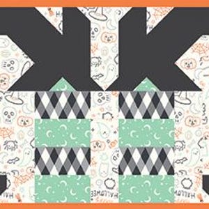 May include: A rectangular table runner featuring a repeating patchwork design with black, white, orange, and mint green colors. The pattern includes geometric shapes, argyle diamonds, and a background print of small Halloween-themed icons.