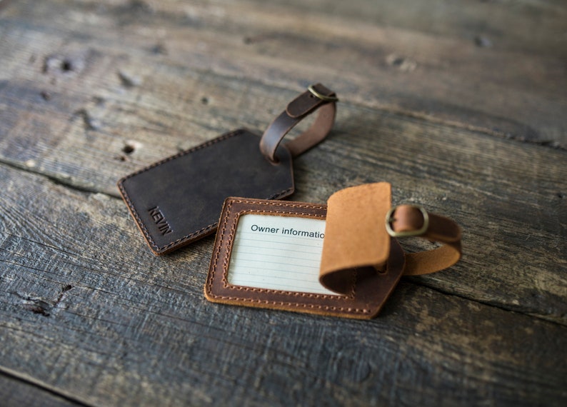 May include: Two leather luggage tags. One is brown with the name "KEVIN" embossed on it. The other is brown and tan with a space for writing "Owner Information".