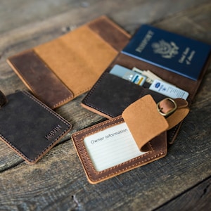 May include: Two brown leather luggage tags with a brass buckle, one with the name "Kevin" embossed on it, and the other with a blank space for "Owner Information". A brown leather passport holder with a blue passport inside.