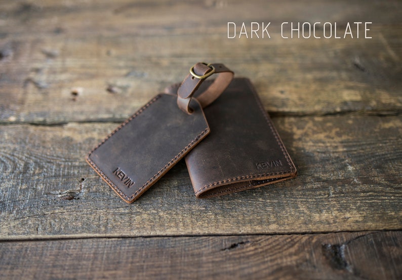 May include: Dark chocolate brown leather luggage tag and passport holder set with the name "Kevin" embossed on each piece.