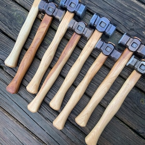 May include: A set of ten  hammer heads with wooden handles. The hammer heads are made of metal and have a polished finish. The handles are made of wood and have a natural finish.