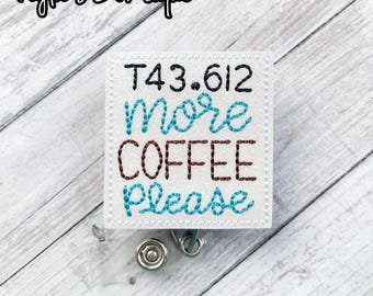 May include: White square badge holder with a white background and blue, brown, and black embroidery that reads "T43.612 More Coffee Please".
