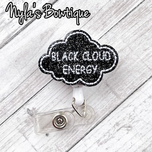 May include: Black glitter cloud-shaped badge holder with the text "Black Cloud Energy" in white. The badge holder is attached to a white retractable badge reel.