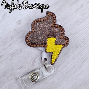 May include: A brown glitter poop emoji with a yellow lightning bolt badge reel.