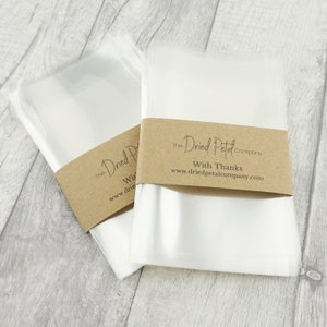 May include: A pack of clear cellophane bags with a brown paper label that reads "The Dried Petal Company" and "With Thanks" with the website address "www.driedpetalcompany.com".