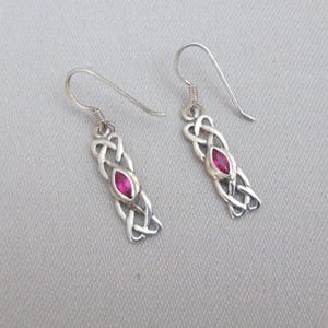 May include: A pair of silver Celtic knot earrings with a pink gemstone in the center of each knot.