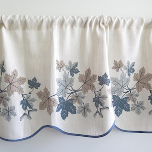 Peut inclure: Valance crème avec un motif répété de feuilles d'érable bleues, grises et marron. Le bord inférieur est orné d'une bordure bleue et le haut est froncé pour l'accrochage. Un élément décoratif pour fenêtre.