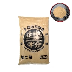 Pode incluir: Um saco de papel castanho cheio de um pó bege etiquetado como "地之粉" (que significa "pó de terra") em japonês. O saco também apresenta o texto "京都山科特産" (que significa "especialidade de Kyoto Yamashina") e "京都府砥之粉工業協同組合" (que significa "Cooperativa Industrial de Pó Toino da Província de Kyoto"). O saco está selado e pronto para uso.