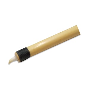 Puede incluir: Primer plano de una flecha de madera con una pluma blanca y una banda negra cerca de la punta.
