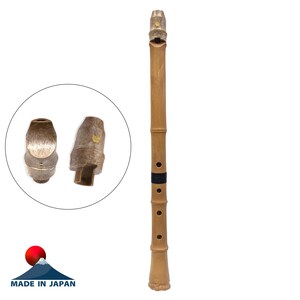 May include: A light brown bamboo flute with four finger holes, a black band, and a textured mouthpiece. A circular inset shows two views of the mouthpiece, which features a small gold-coloured emblem. The text "MADE IN JAPAN" is visible below.