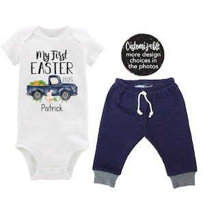 May include: A white bodysuit with the text "My First Easter 2025" and a blue truck with a bunny and carrots. The text "Patrick" is below the truck. A pair of navy blue trousers with a white drawstring.