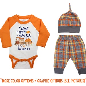 May include: Orange and white baby onesie with the text "Cutest Pumpkin in the Patch" and a train with pumpkins. The onesie has a blue and white plaid hat and pants.