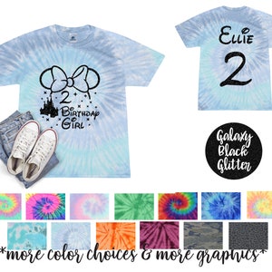 Peut inclure: Un t-shirt bleu tie-dye avec un motif en paillettes noires représentant un château, un nœud et le texte "2 Birthday Girl". Le dos du t-shirt porte le nom "Ellie" et le chiffre "2" en paillettes noires.