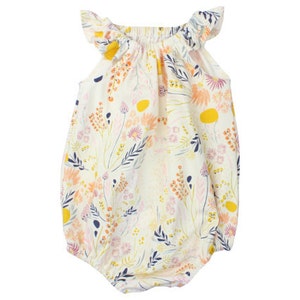 May include: A white baby onesie with a floral print in shades of pink, yellow, and blue. The onesie has ruffled sleeves and a gathered neckline.