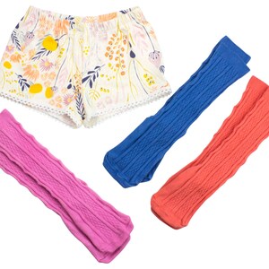 May include: Three pairs of knit leg warmers in pink, blue, and coral. The leg warmers have a cable knit pattern.