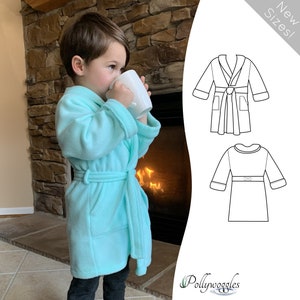 May include: A child wearing a light blue fleece robe with a tie belt. The robe has a shawl collar and pockets. The child is holding a white mug. The image also includes a line drawing of the robe in two different views. The text "New Sizes!" is in the upper right corner of the image. The text "Pollywoggles" is in the lower right corner of the image.