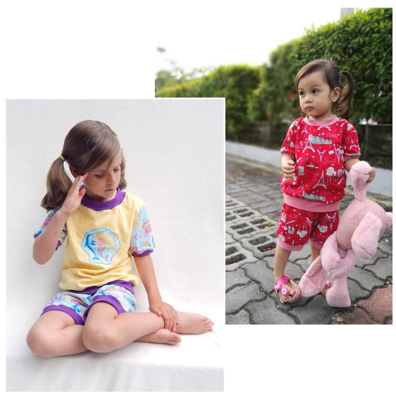 May include: Two young girls wearing colorful pajamas. The girl on the left is wearing a yellow and purple pajama set with a mermaid design. The girl on the right is wearing a red and pink pajama set with a Parisian theme.