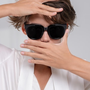 Woman wearing polarized sunglasses with an oversized silhouette and neutral outfit
