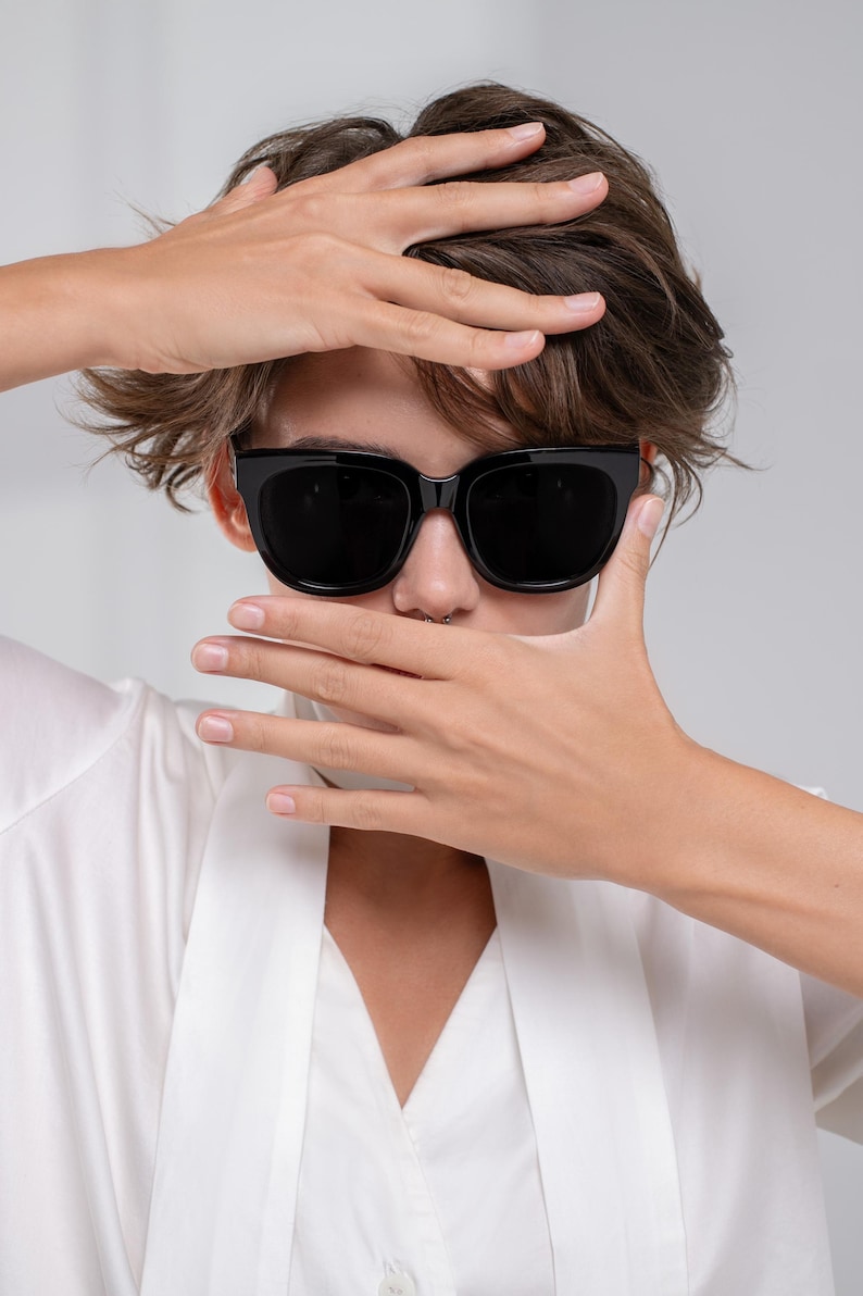 Woman wearing polarized sunglasses with an oversized silhouette and neutral outfit
