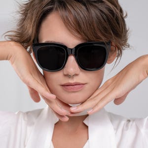 Modern black sunglasses with dark lenses and a softly rounded shape