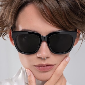 Modern black sunglasses with dark lenses and a softly rounded shape