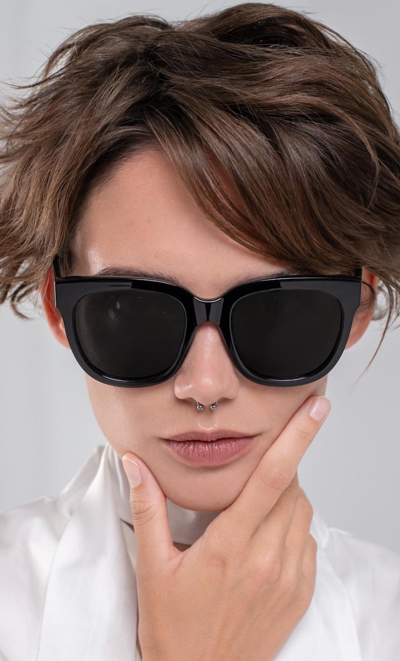 Modern black sunglasses with dark lenses and a softly rounded shape