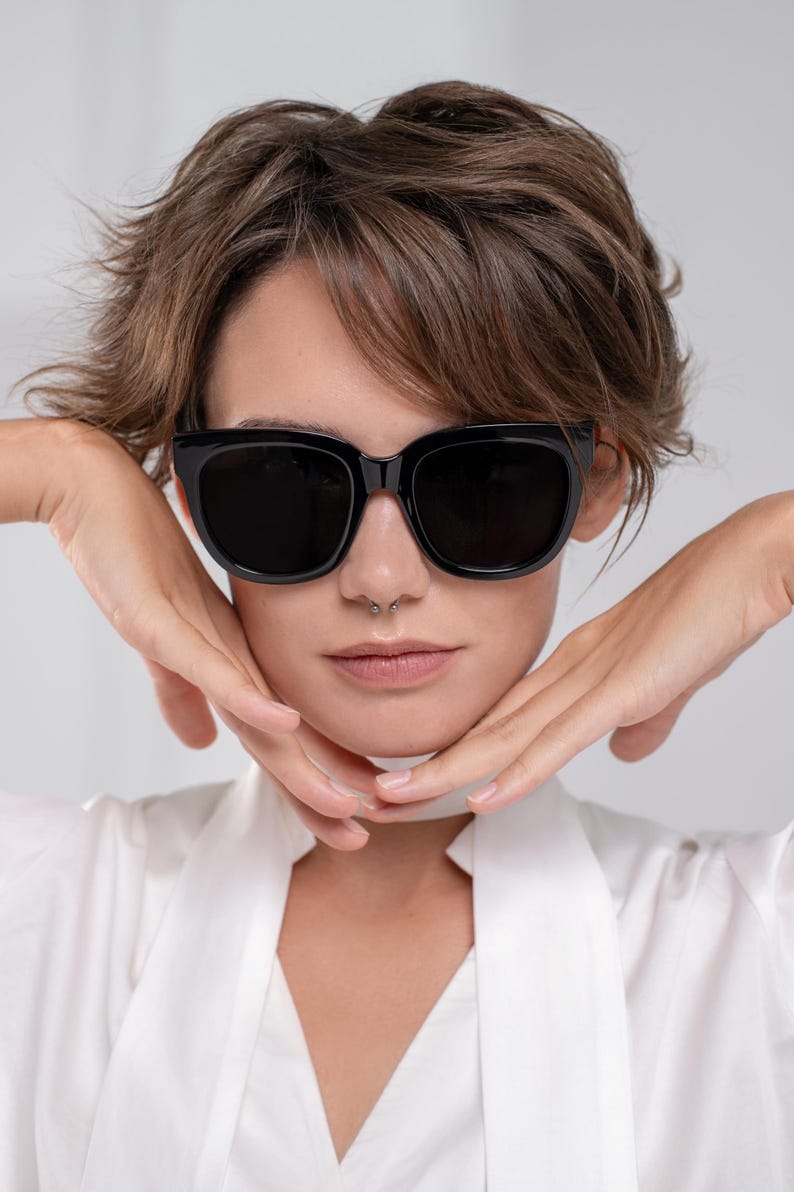 Oversized black sunglasses with a bold statement frame styled on a model