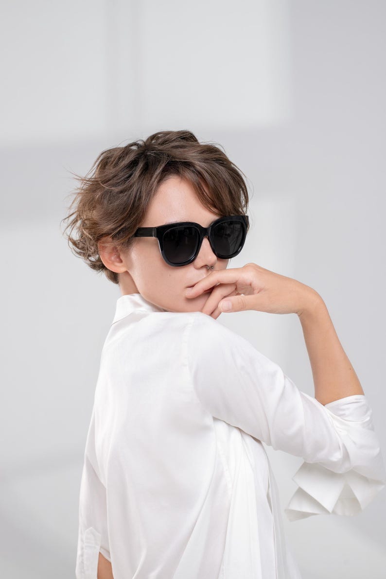 Woman wearing oversized black sunglasses with dark polarized lenses and a modern look