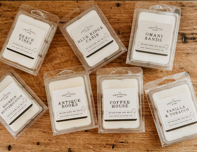 May include: Assortment of ten wax melts in clear plastic packaging. Each melt features a different scent and design with the brand name "The Driftwood Home" printed on the label.