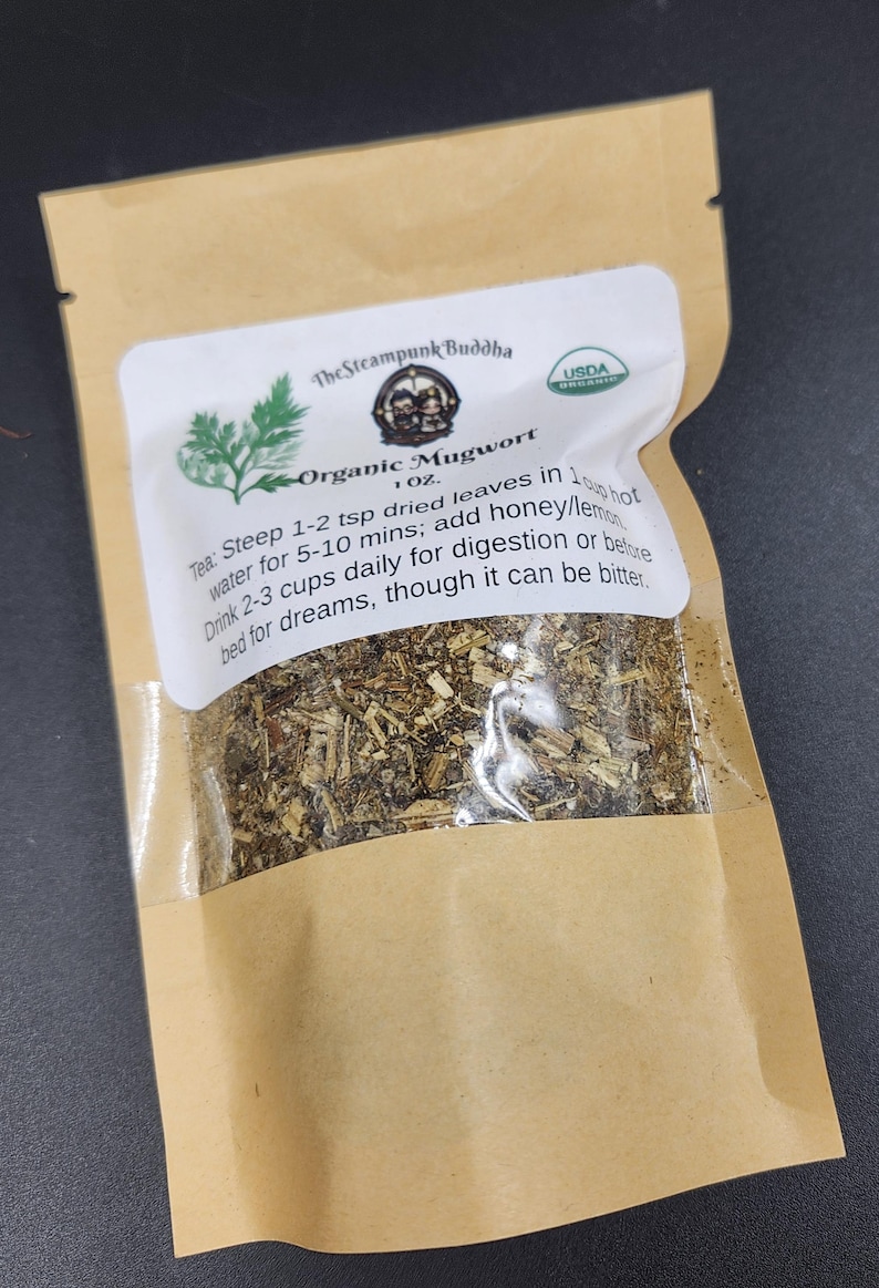 May include: A brown paper bag with a clear window containing dried herbs. The label reads "Organic Mugwort" and includes instructions for use. The bag is sealed and has a USDA organic seal.