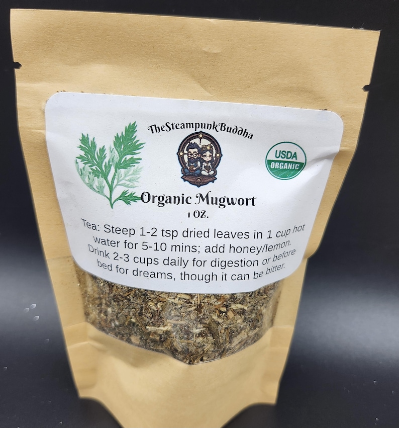 May include: A kraft paper bag containing organic mugwort tea. The label features the text "The Steampunk Buddha" and "Organic Mugwort." The label also includes the USDA Organic seal and instructions for use. The bag contains 1 oz of tea.