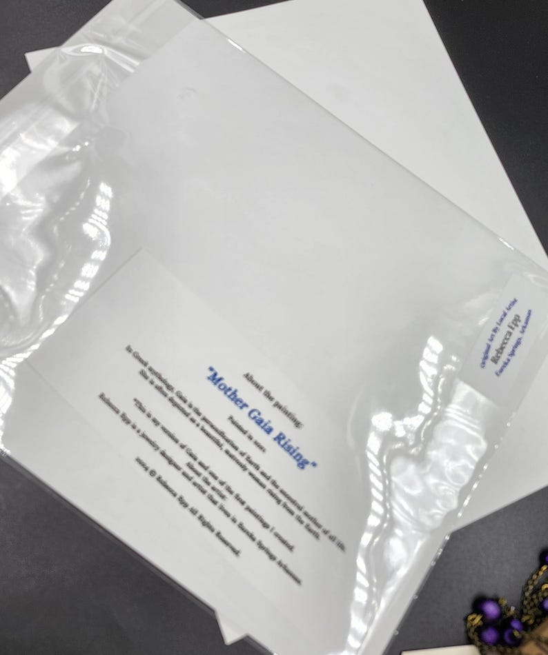 K&ouml;nnte beinhalten: Ein Druck von "Mother Gaia Rising" von Rebecca Epp, in einer transparenten Plastikh&uuml;lle. Der Druck enth&auml;lt Text, der die Inspiration des Gem&auml;ldes aus der griechischen Mythologie beschreibt. Das Kunstwerk ist auf wei&szlig;em Papier.