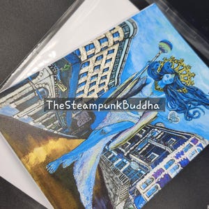 Op de afbeelding: Een originele kunstafdruk met een blauwhuidige figuur met lang blauw haar, een gouden kroon en een staf, tegen een achtergrond van gestileerde gebouwen. De tekst "TheSteampunkBuddha" is zichtbaar. Het kunstwerk zit in een transparante plastic hoes.