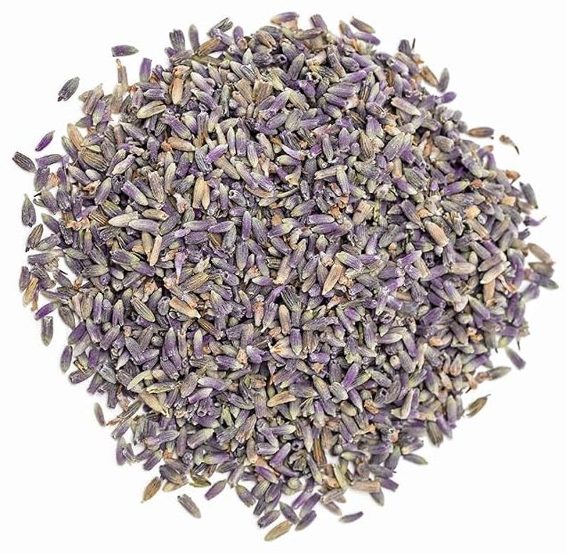 Puede incluir: Primer plano de capullos de lavanda secos, que muestran una mezcla de tonos morados y beige. Los capullos son peque&ntilde;os y texturizados, con una vista detallada que resalta sus caracter&iacute;sticas naturales. La imagen est&aacute; sobre un fondo blanco, enfatizando el producto natural.