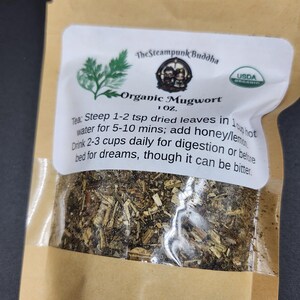 May include: A brown paper bag containing organic mugwort tea. The bag has a white label with the text "The Steampunk Buddha" and "Organic Mugwort." The label also includes instructions for brewing the tea and a USDA organic seal.