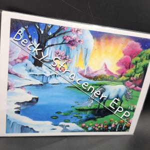Puede incluir: Una impresi&oacute;n art&iacute;stica de fantas&iacute;a que presenta un unicornio blanco cerca de un lago. La obra de arte muestra un paisaje vibrante con una cascada, &aacute;rboles rosados y una colorida puesta de sol. El texto en la imagen dice "Becky Stracener EPP".