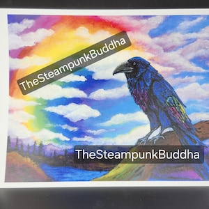 Op de afbeelding: Een levendige print met een gedetailleerde illustratie van een raaf die op een rots zit, tegen een achtergrond van een regenboog en een bewolkte lucht. De raaf is afgebeeld met blauwe en paarse veren. De tekst "TheSteampunkBuddha" staat over de afbeelding.