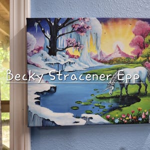 Puede incluir: Una obra de arte en lienzo enmarcada que representa un paisaje de fantas&iacute;a con un unicornio blanco bebiendo de un lago. La obra presenta una monta&ntilde;a nevada, &aacute;rboles rosas y el texto "Becky Stracener Epp".
