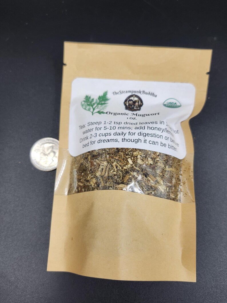 May include: A brown paper bag with a clear window containing dried herbs. The bag has a white label with the text "Organic Mugwort" and instructions for use. A US quarter is next to the bag.