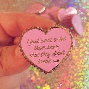 Op de afbeelding: Roze hartvormige emaille pin met een gouden geschulpte rand. De pin heeft de tekst "I just want to let them know that they didn't break me" in gouden letters. Een decoratief accessoire.
