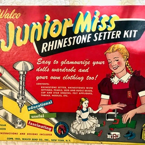 May include: A vintage box for a Junior Miss Rhinestone Setter Kit. The box is red with yellow and blue lettering. The kit includes a tool for setting rhinestones, beads, and sequins. The box also includes instructions and designs for using the kit.  The text on the box reads: "Walco Junior Miss Rhinestone Setter Kit. Easy to glamourize your doll's wardrobe and your own clothing too!"