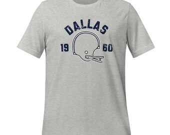 May include: A heather grey t-shirt with a vintage-style graphic of a football helmet and the text "Dallas 19 60".