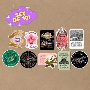 May include: A set of 10 stickers with various designs and text. Designs include a pink orchid, a black rectangle with "Back from the Dead", and a green circle with "Perfume & Milk". The stickers have a witchy, mystical theme.