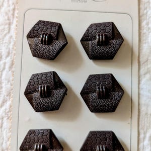 May include: A card of six vintage dark brown hexagonal buttons. Each button has a textured surface and a raised, vertical design. The card reads "La Mode" and "Superior Quality" with "Czechoslovakia" at the bottom.